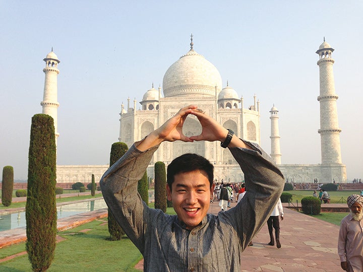 Student making the "O" with their hands standing in front of the Taj Mahal in India