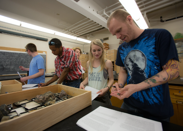 Teacher showing a student a rock in a geology lab