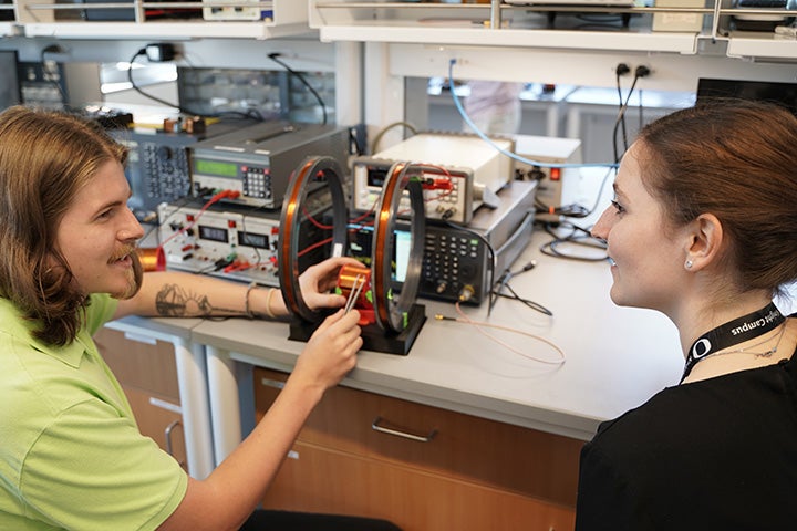 Two students working with a machine in the Knight Campus bioengineering lab.