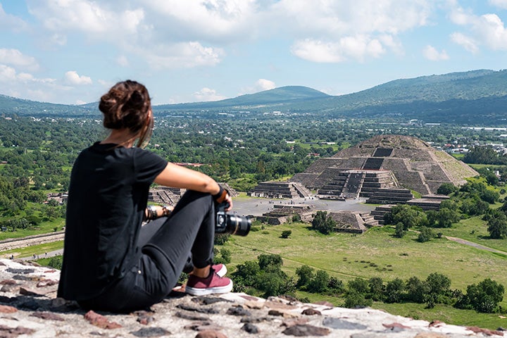 Student with camera sitting and overlooking the Teotihuacan ruins