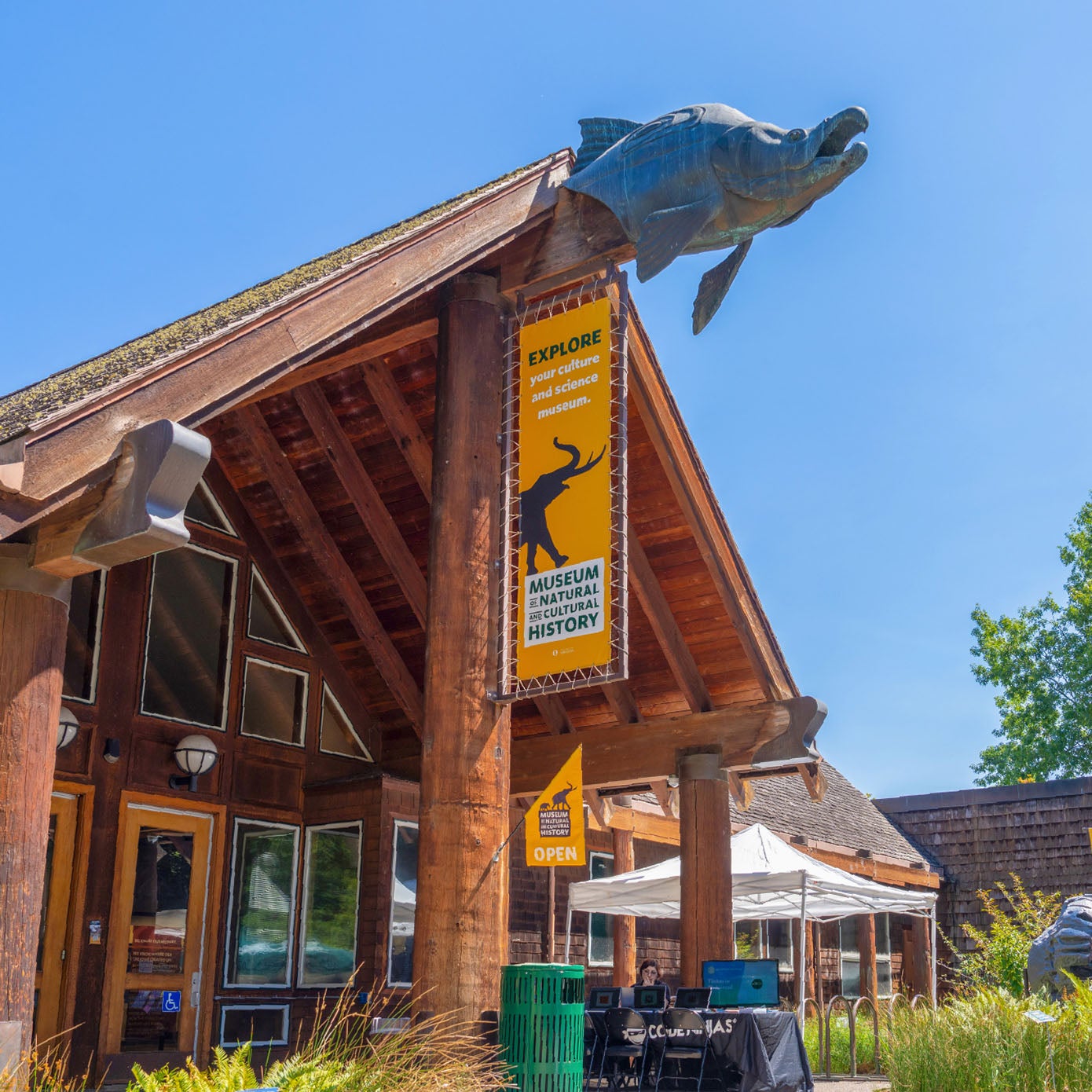 A wooden sculpture of a salmon head greets visitors at the entrance to the Museum of Natural and Cultural History, located on campus.