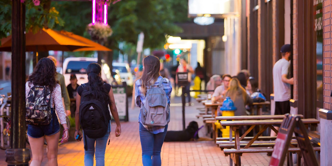 Students strolling through bustling, downtown Eugene in the evening.