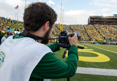 Student with camera in the end zone of Autzen Stadium 